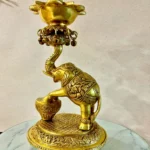 Ornate gold brass sculpture of a mythical creature with a curved neck and intricate patterns, displayed on a marble-topped glass table.  thebrasshandicrafts.com