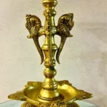 Ornate gold hookah with winged metal motifs and a tall central stem, decorative base.  thebrasshandicrafts.com
