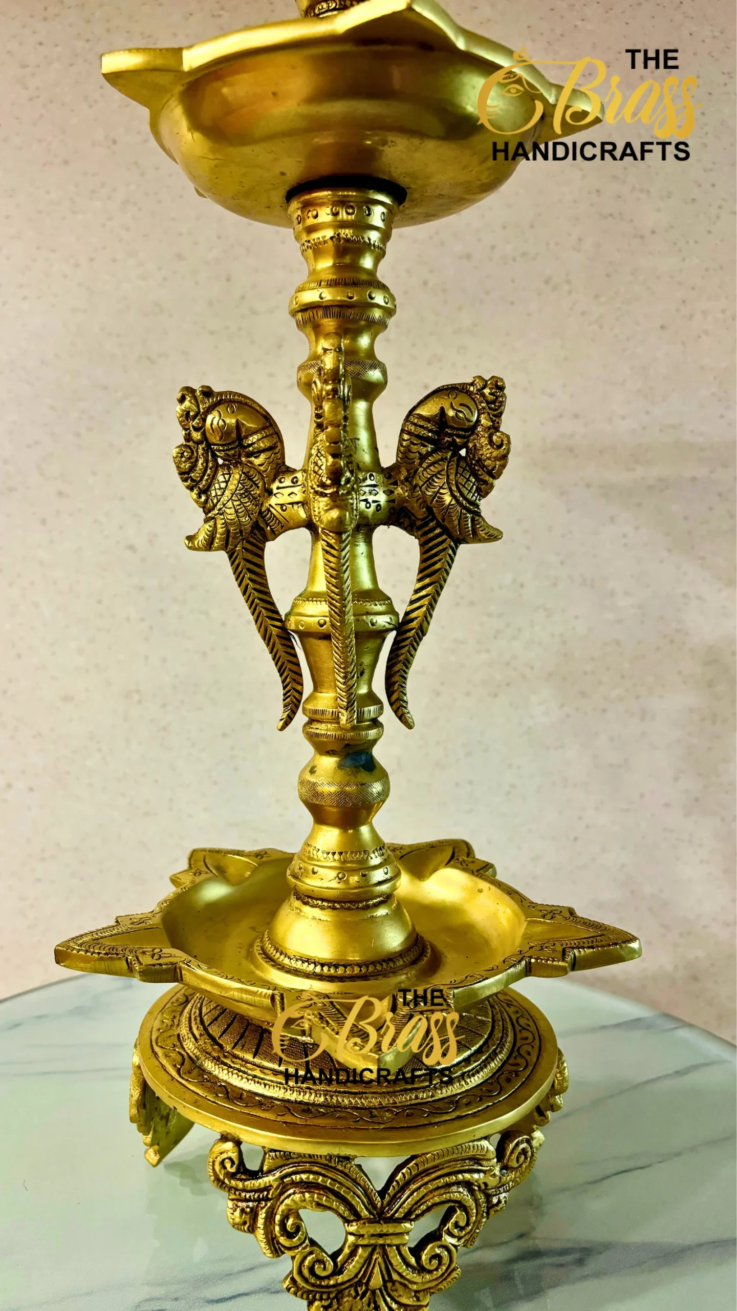 Ornate gold hookah with winged metal motifs and a tall central stem, decorative base.  thebrasshandicrafts.com