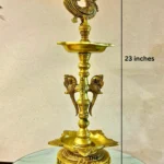 Ornate brass peacock finial atop a tall decorative pedestal, displayed on a marble surface, 23 inches tall with a 7.5 inch base.  thebrasshandicrafts.com