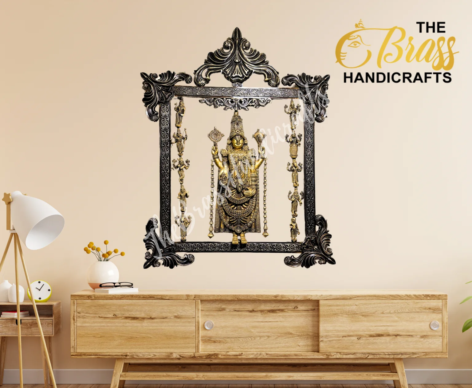 Ornate black frame containing a gold Hindu deity statue on a beige wall, with The Brass Handicrafts logo in the top right place.  thebrasshandicrafts.com