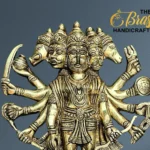 Ornate brass statue of a multi-headed, multi-armed Hindu deity on a blue-gray background; The Brass Handicrafts logo appears in the top right.  thebrasshandicrafts.com