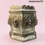 Ornate metal box with detailed embossed panels and beadwork, set against a pink background (decorative brass handicraft).  thebrasshandicrafts.com