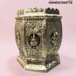 Ornate silver-toned metal chest with floral and deity reliefs on a pink background, branded 'The Brass Handicrafts' in the corner  thebrasshandicrafts.com