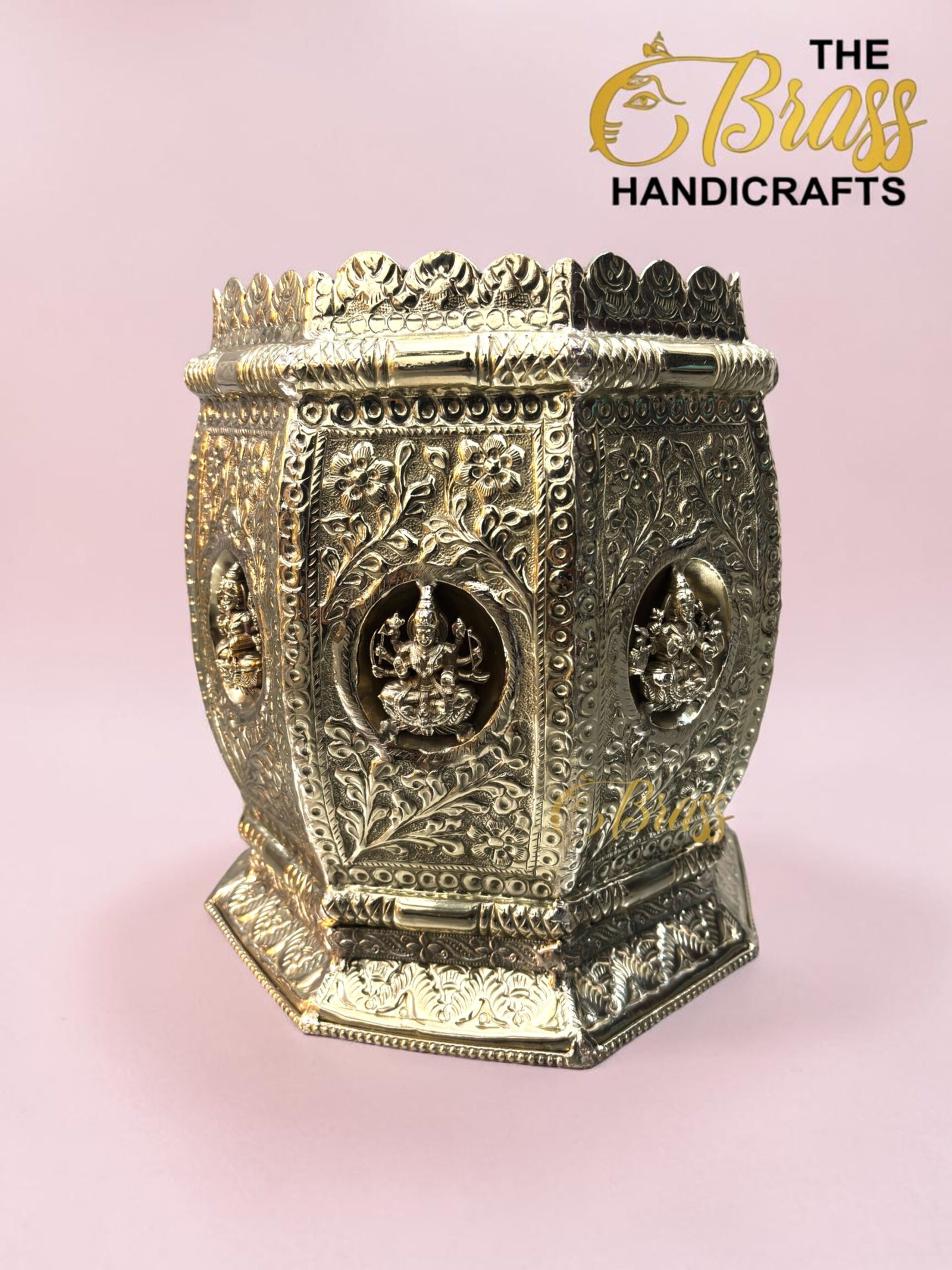 Ornate silver-toned metal chest with floral and deity reliefs on a pink background, branded 'The Brass Handicrafts' in the corner  thebrasshandicrafts.com