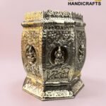 Ornate two-tone metal jewelry chest with floral engravings and a crown ridge against a pink backdrop.  thebrasshandicrafts.com