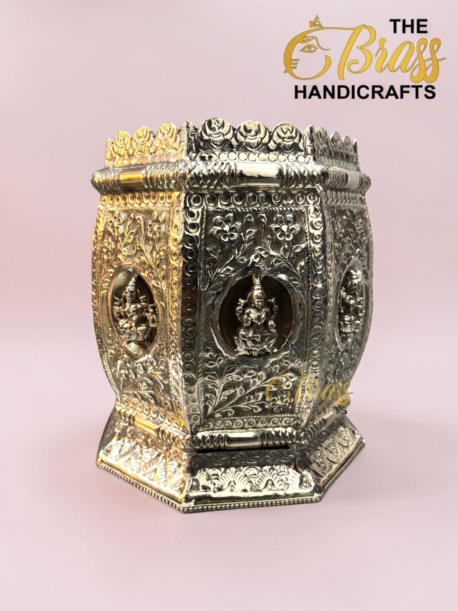 Ornate two-tone metal jewelry chest with floral engravings and a crown ridge against a pink backdrop.  thebrasshandicrafts.com