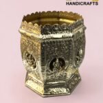 Ornate brass decorative container with a scalloped crown-like rim and intricate floral engravings against a pink background.  thebrasshandicrafts.com