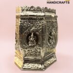 Ornate silver metal box with floral engravings and raised borders, set on a pink backdrop; brand logo 'The Brass Handicrafts' visible.  thebrasshandicrafts.com