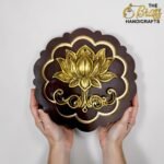 Ornate brown decorative plaque with gold floral design, held by two hands in front of a light background.  thebrasshandicrafts.com
