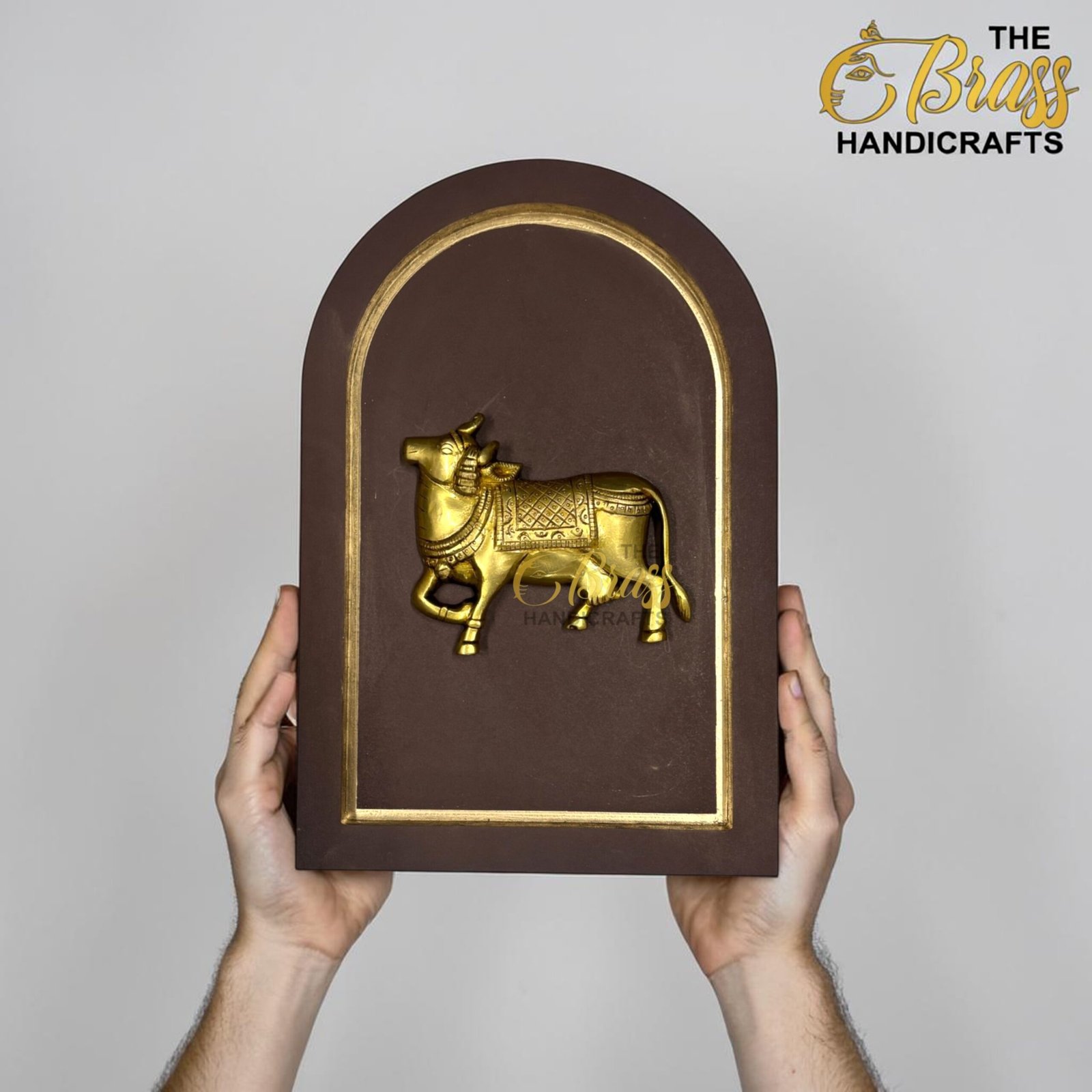 Brown plaque with a gold arched border and a gold horse relief, held by two hands against a gray background, brand visible in corner.  thebrasshandicrafts.com