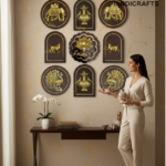 Showroom scene with gold embossed wall plaques (elephants, peacocks and lotus) on a beige wall, and a woman in a cream suit holding a vase next to the display, The Biass Handicrafts logo visible in the corner.  thebrasshandicrafts.com