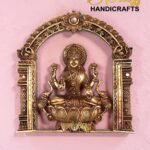 Ornate gold statue of a deity seated in a decorative arch frame on a pink wall, with 'The Boss Handicrafts' logo in the corner.  thebrasshandicrafts.com