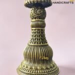 Close-up of an ornate brass pedestal with floral filigree on a pink background; logo reads The Brass Handicrafts in the corner.  thebrasshandicrafts.com