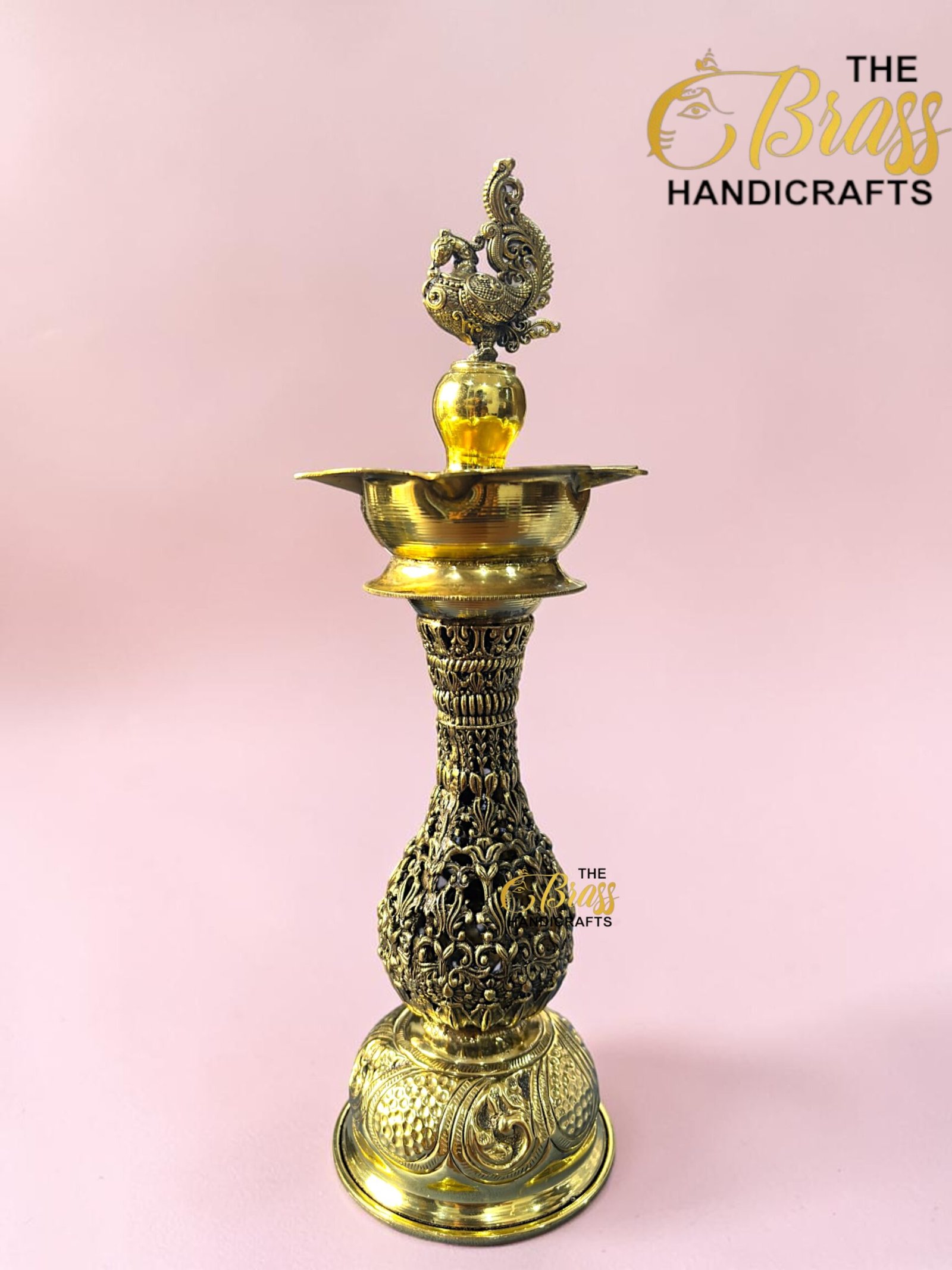 Ornate brass hookah with intricate engravings against a pink background; The Brass Handicrafts logo visible in the corner.  thebrasshandicrafts.com