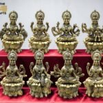 IMG_5767 3 - thebrasshandicrafts.com Row of brass Hindu deity statues on a red velvet cloth with The Brass Handicrafts logo in the top left corner. thebrasshandicrafts.com