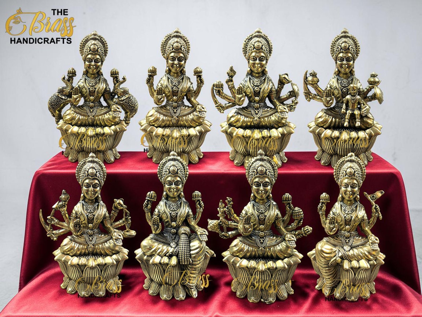 IMG_5767 3 - thebrasshandicrafts.com Row of brass Hindu deity statues on a red velvet cloth with The Brass Handicrafts logo in the top left corner. thebrasshandicrafts.com