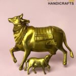 Gold brass statue of a standing horse with a foal beneath it on a pink background.  thebrasshandicrafts.com