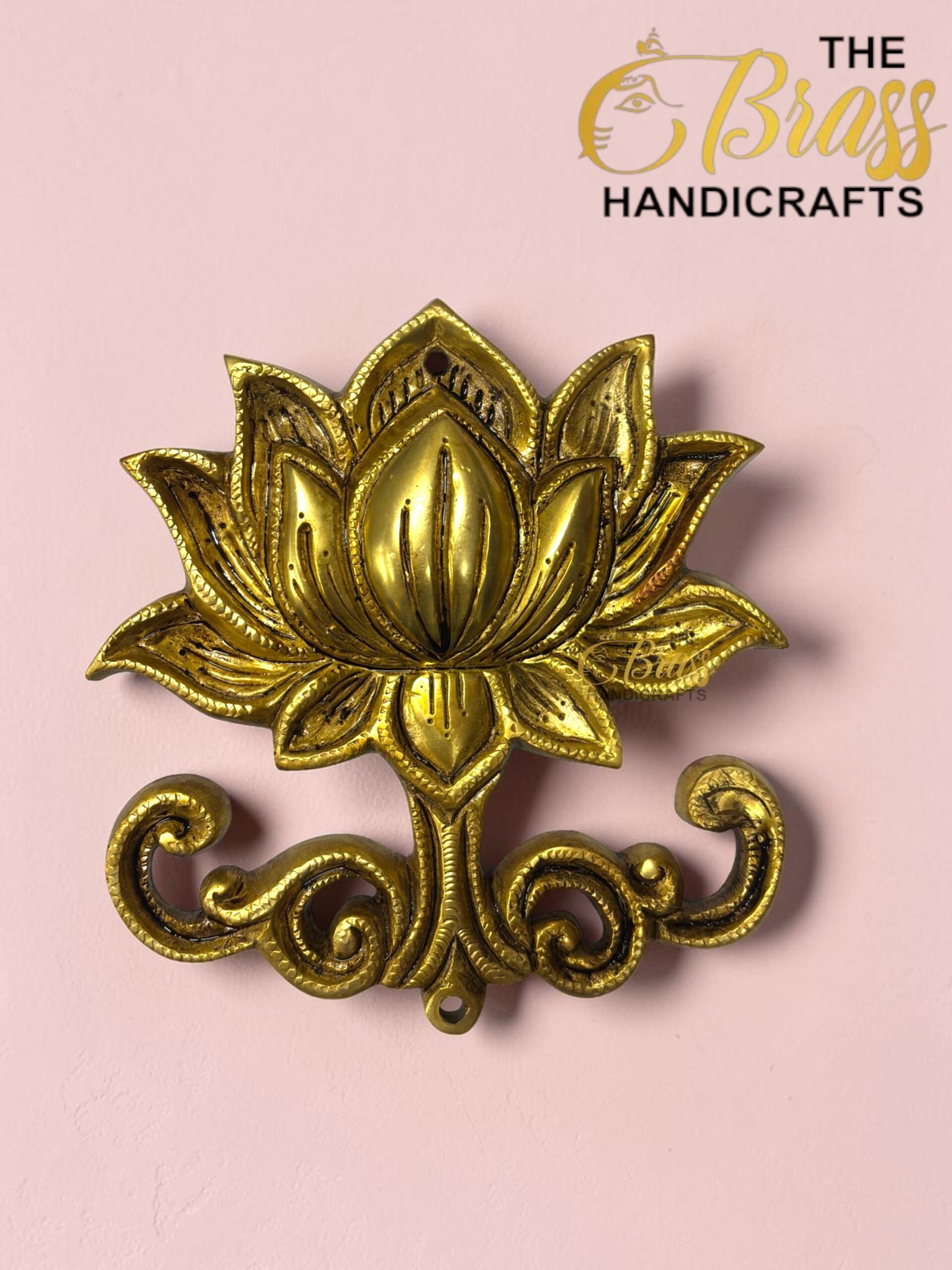 Gold decorative metal flower ornament on a pink background with a 'The Brass Handicrafts' logo in the corner.  thebrasshandicrafts.com