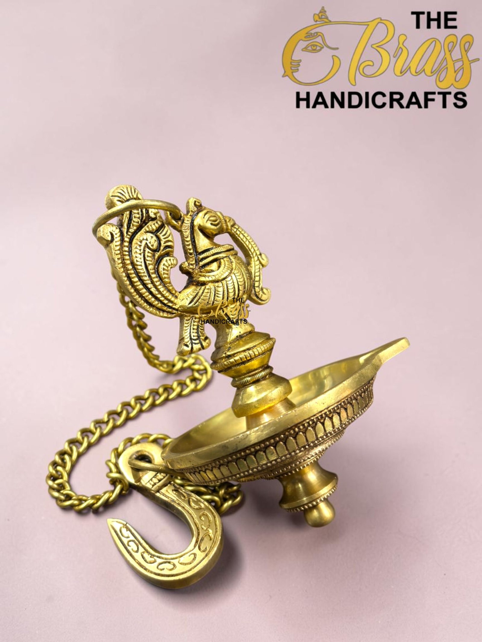 Close-up of a gold ornate brass hookah top with intricate filigree against a pink background, chain draped nearby  thebrasshandicrafts.com