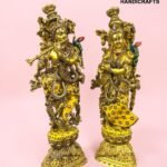 IMG_5924 - thebrasshandicrafts.com Two gold-toned, jewel-encrusted statues standing side by side on a pink background (brand watermark visible). thebrasshandicrafts.com