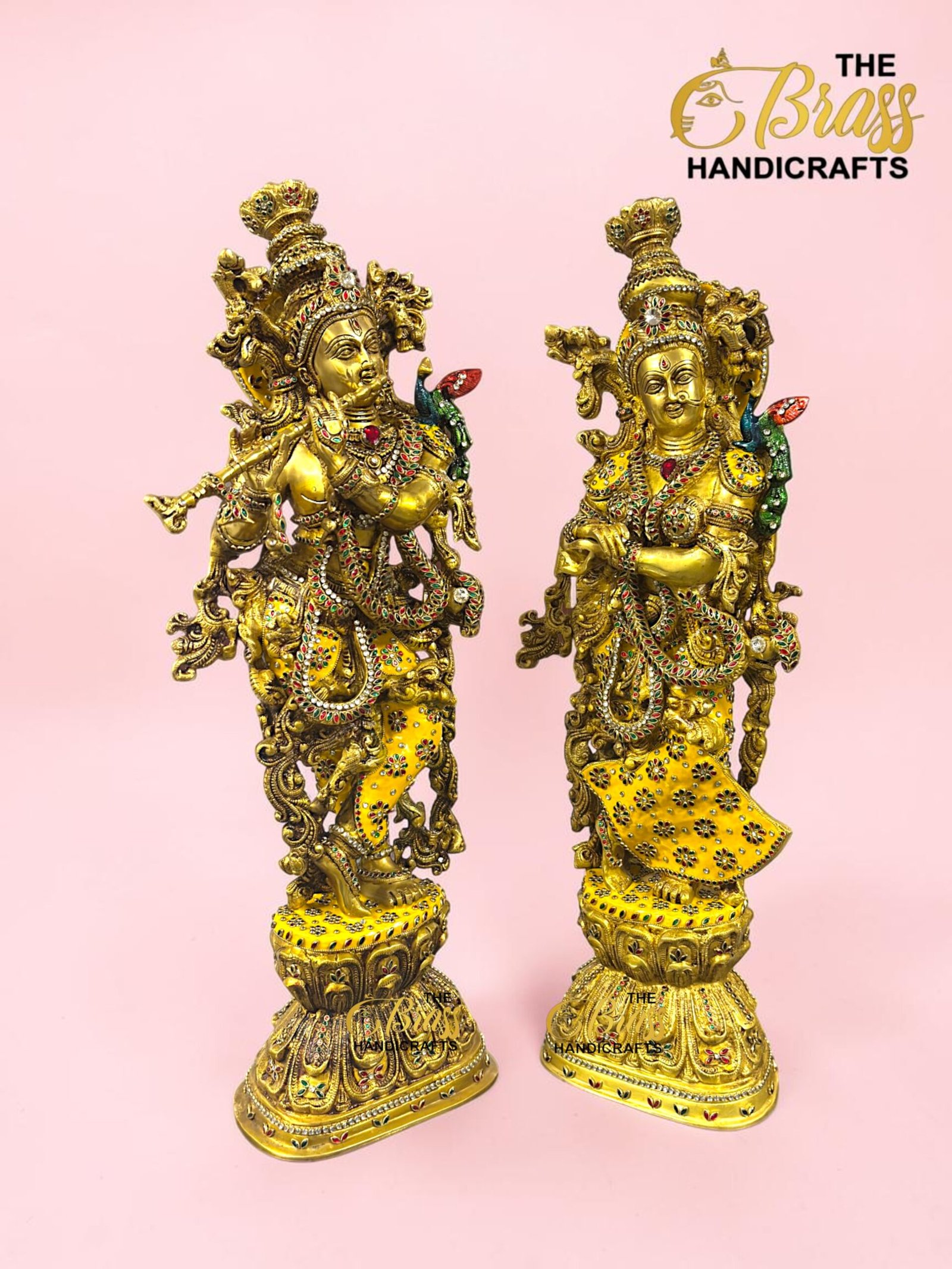 IMG_5924 - thebrasshandicrafts.com Two gold-toned, jewel-encrusted statues standing side by side on a pink background (brand watermark visible). thebrasshandicrafts.com