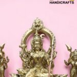 Gold brass statue of a multi-armed Hindu deity displayed against a pink background, part of a handicrafts collection.  thebrasshandicrafts.com