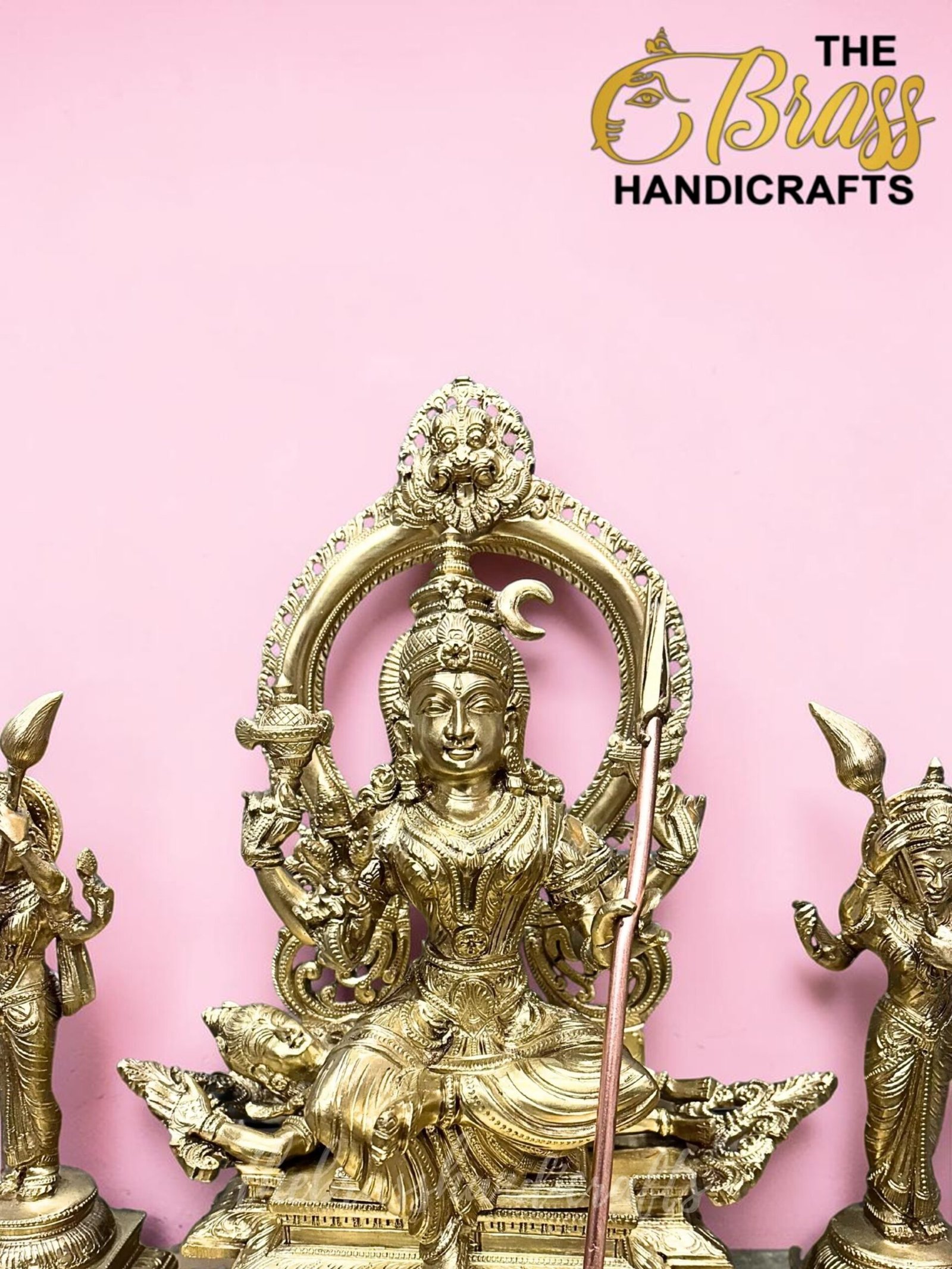 Gold brass statue of a multi-armed Hindu deity displayed against a pink background, part of a handicrafts collection.  thebrasshandicrafts.com
