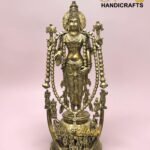 Brass statue of a multi-armed Hindu deity with ornate jewelry and garlands, standing on a decorative base against a pink background.  thebrasshandicrafts.com