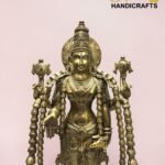 Gold brass statue of a multi-armed Hindu deity with ornate jewelry, set against a pale pink background; logo 'The Brass Handicrafts' appears in the top-right corner.  thebrasshandicrafts.com