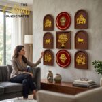 Woman seated on a sofa looking at gold relief plaques mounted in circular and arched frames on a living room wall.  thebrasshandicrafts.com