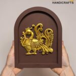 Brown arched plaque featuring a gold ornate mythical horse with wings being held by two hands. The watermark 'The Brass Handicrafts' is visible.  thebrasshandicrafts.com