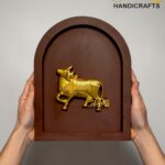 Person holds a brown arched plaque with a golden horse relief; 'The Brass Handicrafts' logo visible in corner.  thebrasshandicrafts.com