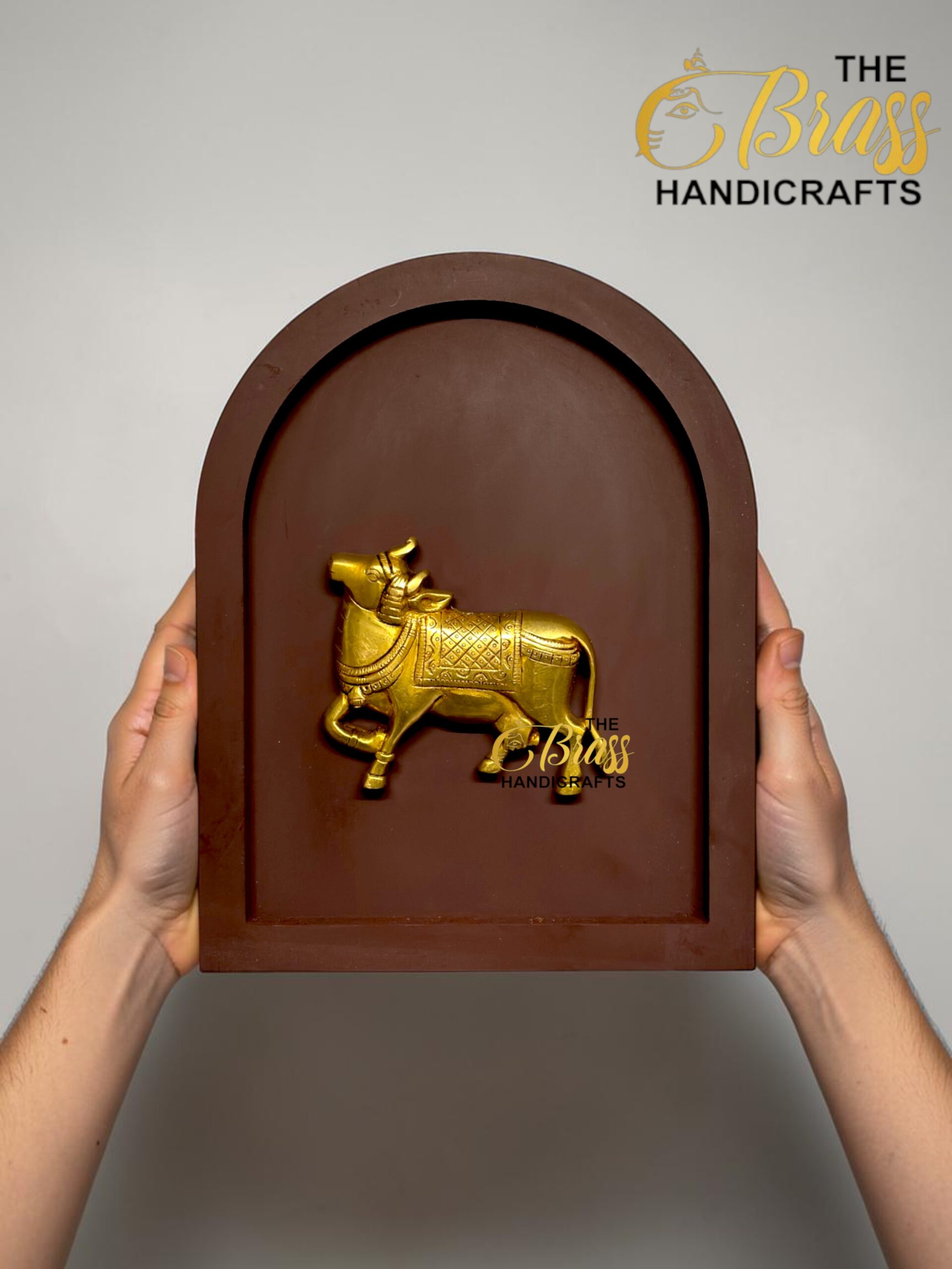 Person holds a brown arched plaque with a golden horse relief; 'The Brass Handicrafts' logo visible in corner.  thebrasshandicrafts.com