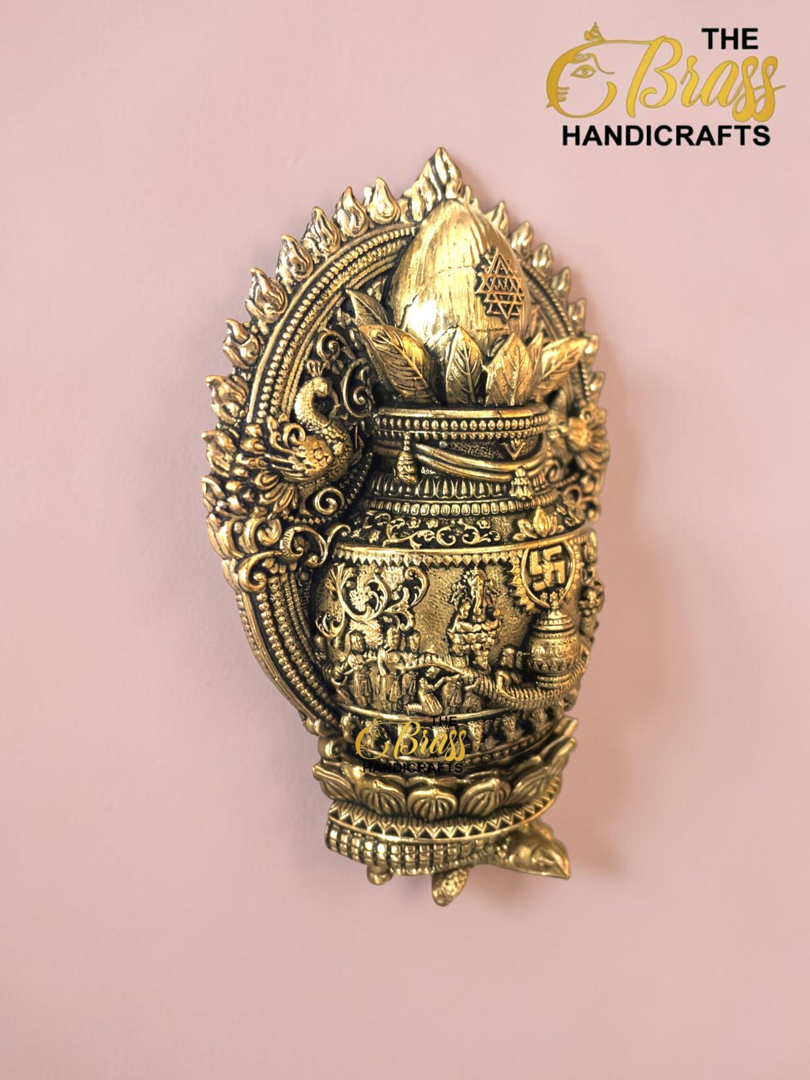 IMG_6159 - thebrasshandicrafts.com Intricately detailed gold-brass decorative piece with floral motifs, mounted on a pink wall thebrasshandicrafts.com