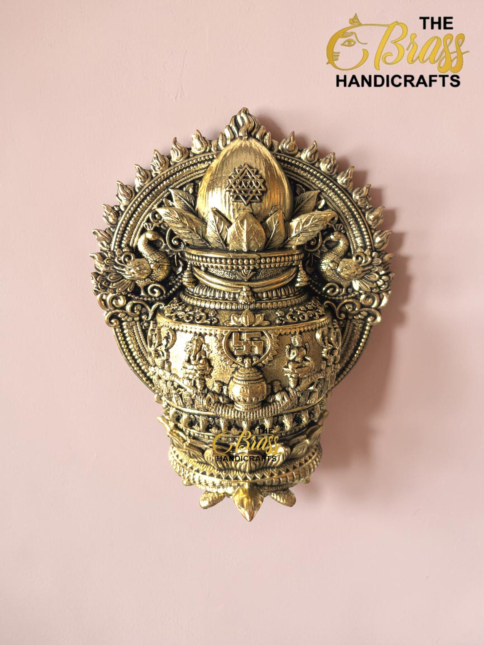IMG_6160 - thebrasshandicrafts.com Intricately detailed gold brass ceremonial ornament with floral and swan motifs on a pink background; watermark reads 'The Brass Handicrafts' thebrasshandicrafts.com