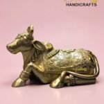 Ornate gold brass elephant statue with intricate engravings on a pink background; The Brass Handicrafts logo in the top right corner  thebrasshandicrafts.com