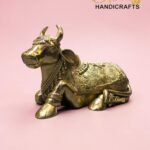 Gold ornate brass bull statue on a pink background with 'The Brass Handicrafts' logo in the corner (product image).  thebrasshandicrafts.com