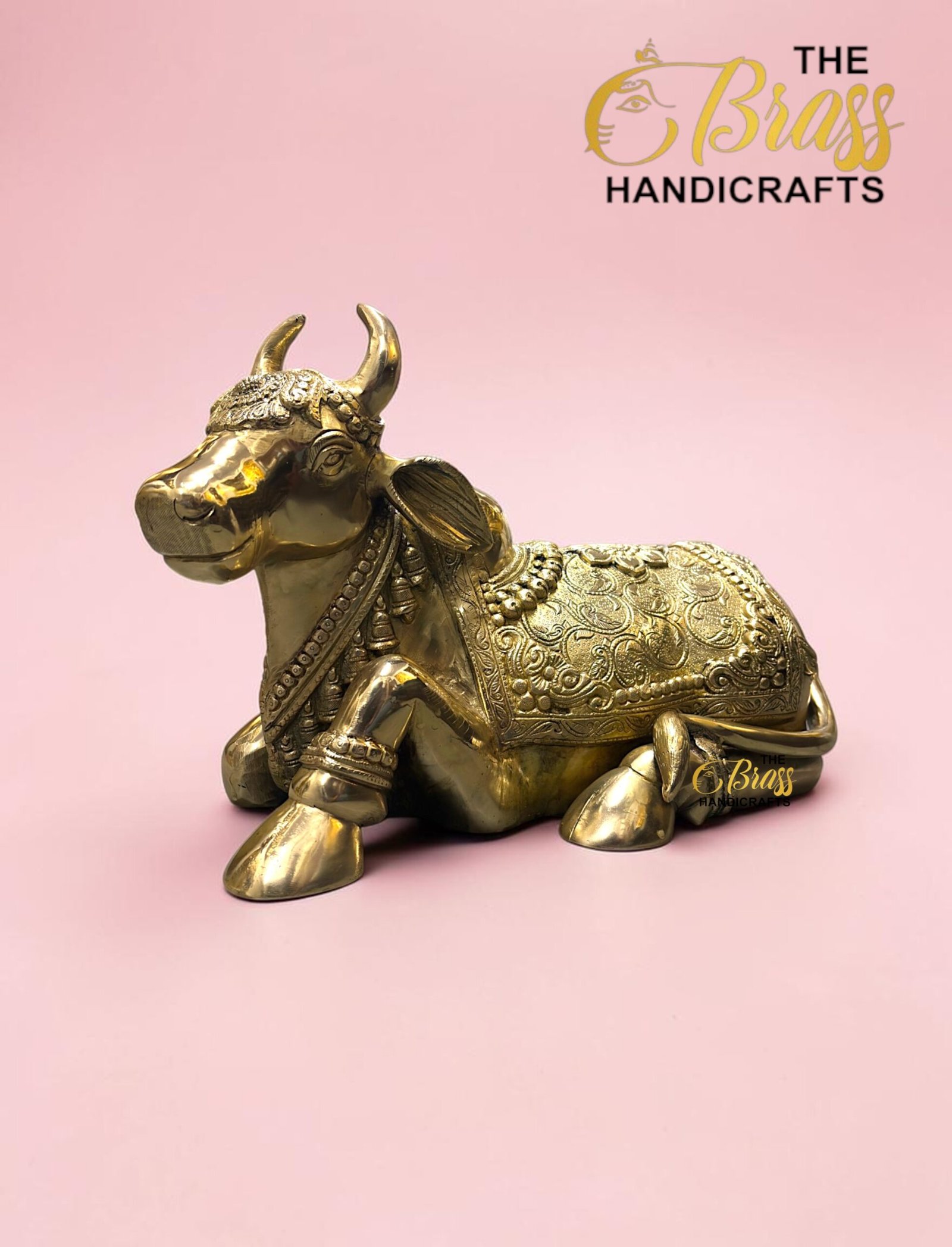 Gold ornate brass bull statue on a pink background with 'The Brass Handicrafts' logo in the corner (product image).  thebrasshandicrafts.com