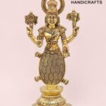 Brass statuette of the Hindu goddess Lakshmi standing on a base, with multiple arms and a lotus held in one hand, set against a pink background.  thebrasshandicrafts.com