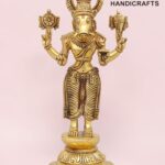 Gold-toned brass statue of the Hindu god Ganesha with an elephant head and multiple arms, holding symbolic objects, on a decorative base against a pink backdrop.  thebrasshandicrafts.com