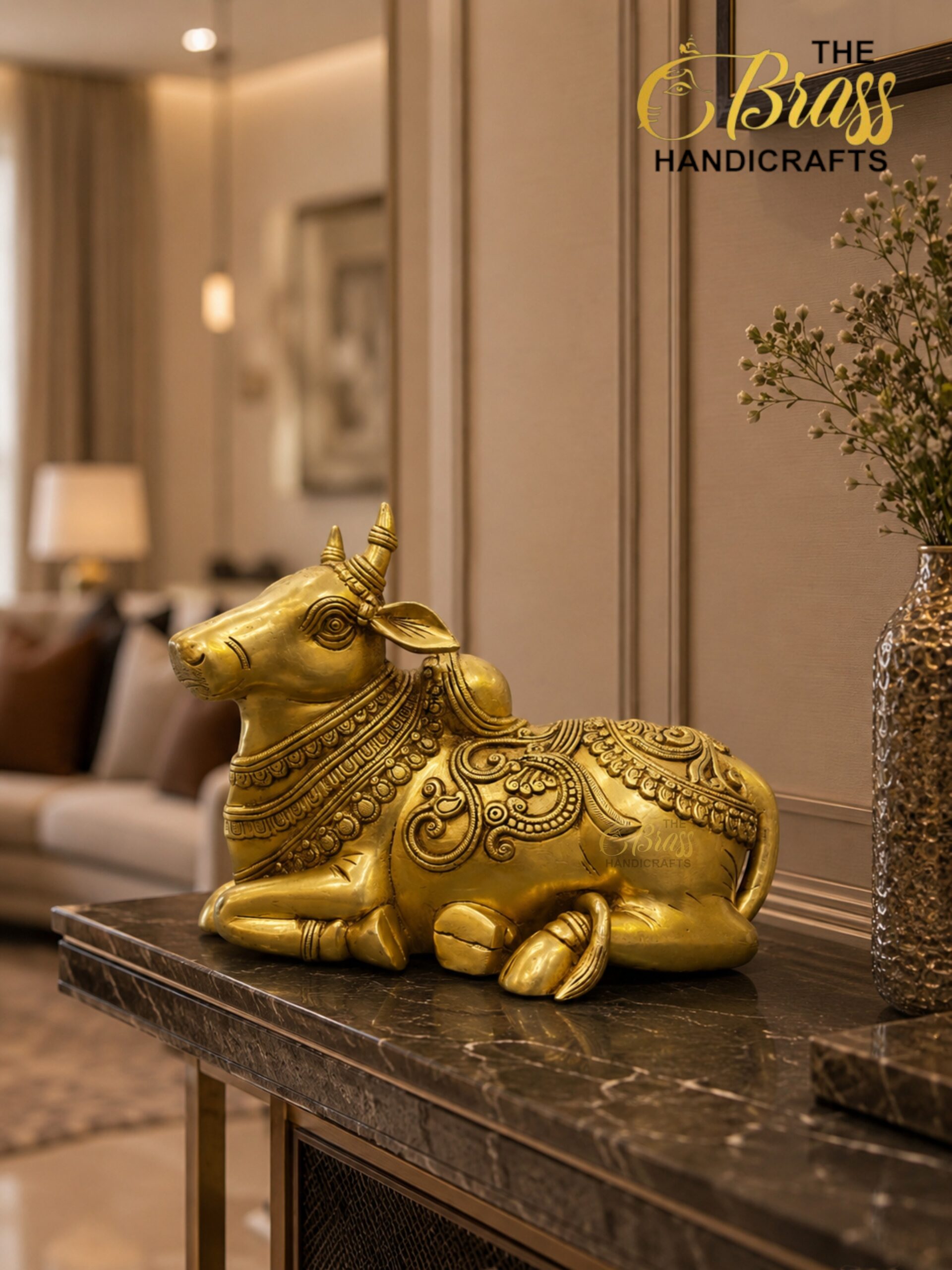 nandi 4 - thebrasshandicrafts.com Gold-toned decorative bull statue with ornate detailing on a marble surface in a luxurious interior. - The Brass Handicrafts setting appears in the scene. thebrasshandicrafts.com
