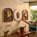 tch 2 - thebrasshandicrafts.com Wall display of three decorative plaques (center round emblem) with a hand reaching toward them; showroom setting. thebrasshandicrafts.com