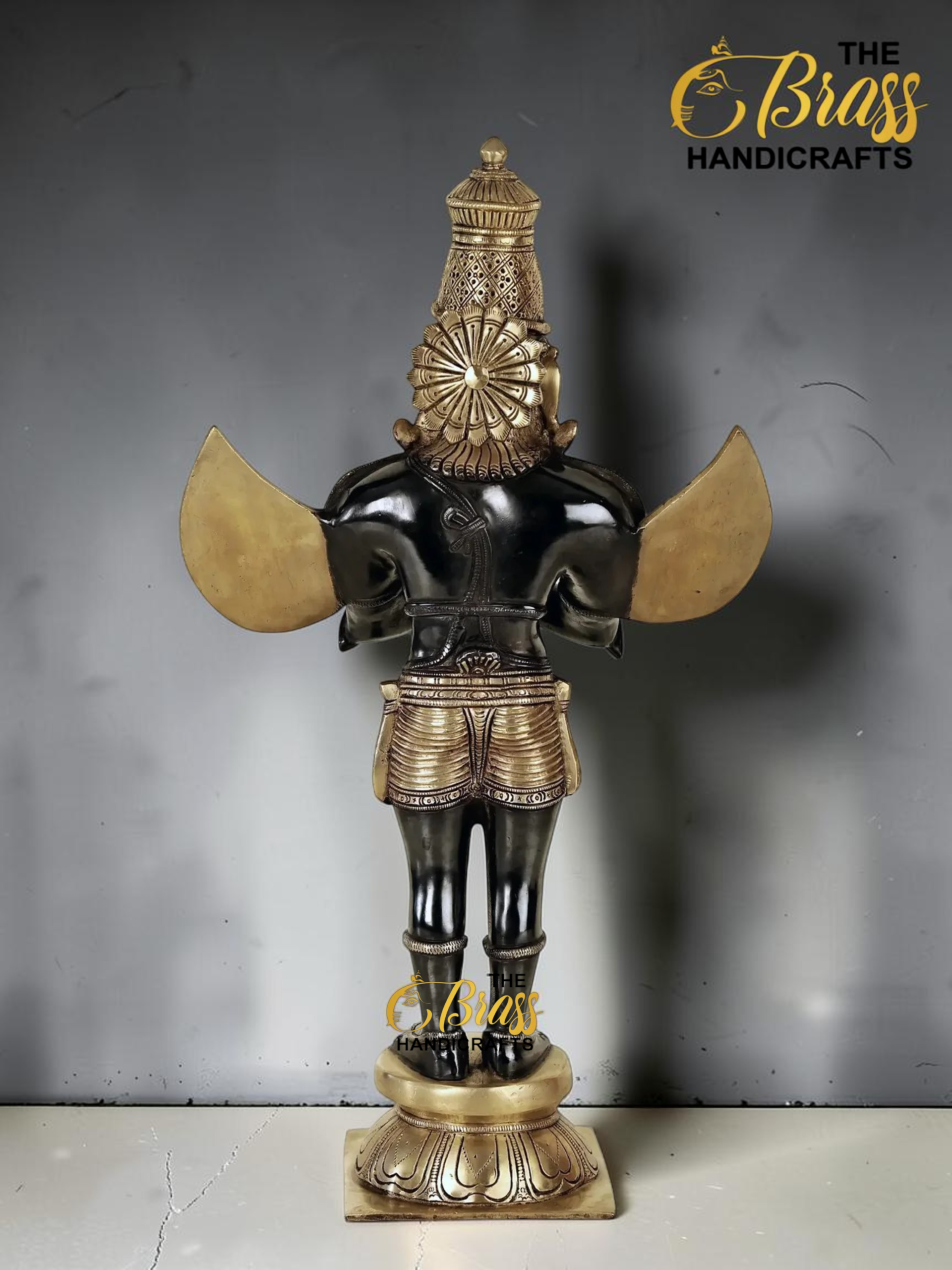 Bronze statue of a Hindu deity with an ornate crown and gold wings, standing on a patterned pedestal.  thebrasshandicrafts.com