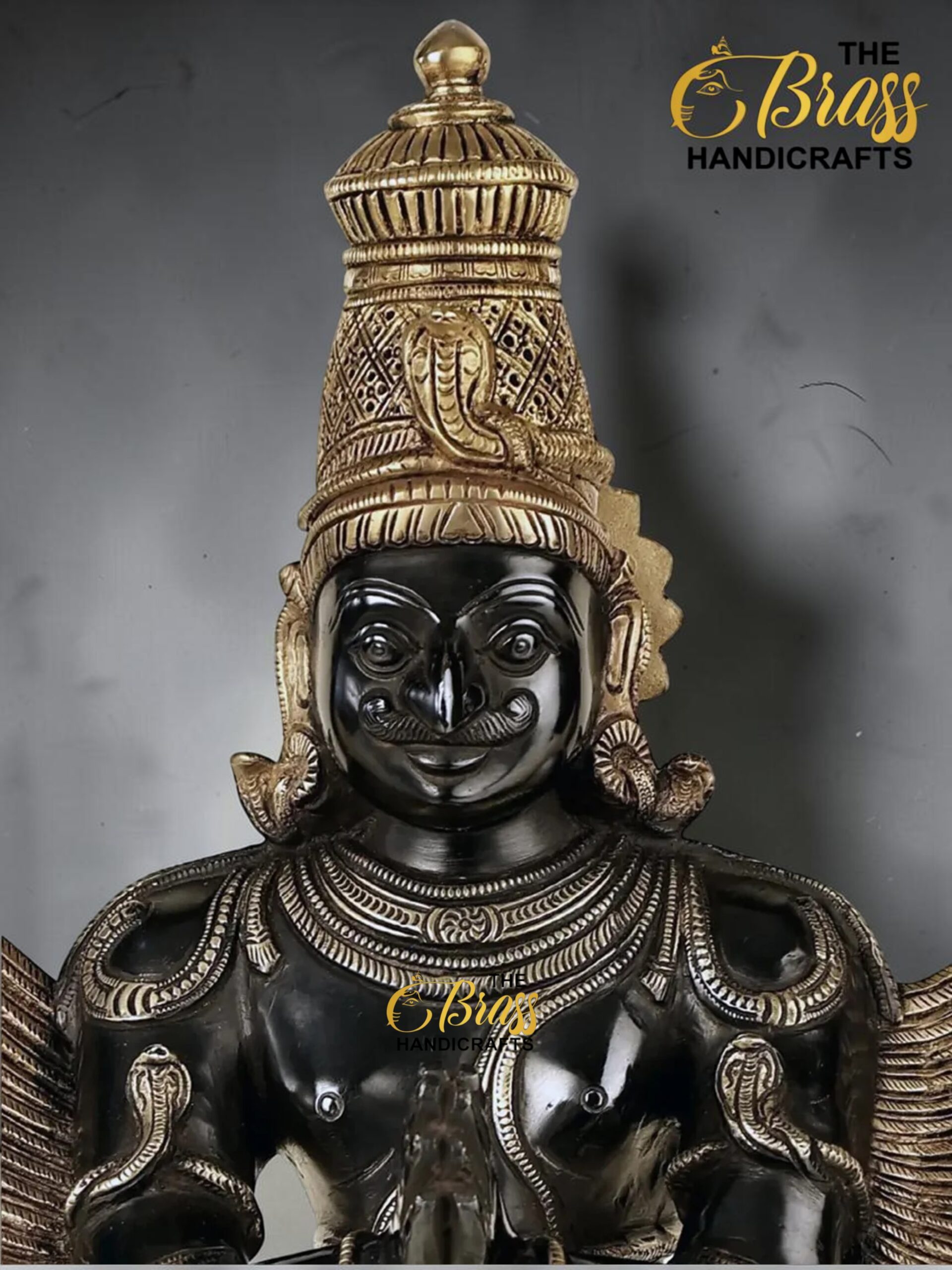 Black and gold statue of the Hindu deity Ganesha with an ornate headdress and detailed jewelry, logo 'The Brass Handicrafts' visible in corner  thebrasshandicrafts.com