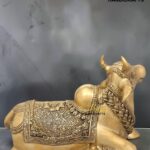 nandi 2 - thebrasshandicrafts.com Gold-toned brass reclining elephant statue with intricate carved patterns, featuring 'The Brass Handicrafts' logo in the corner. thebrasshandicrafts.com
