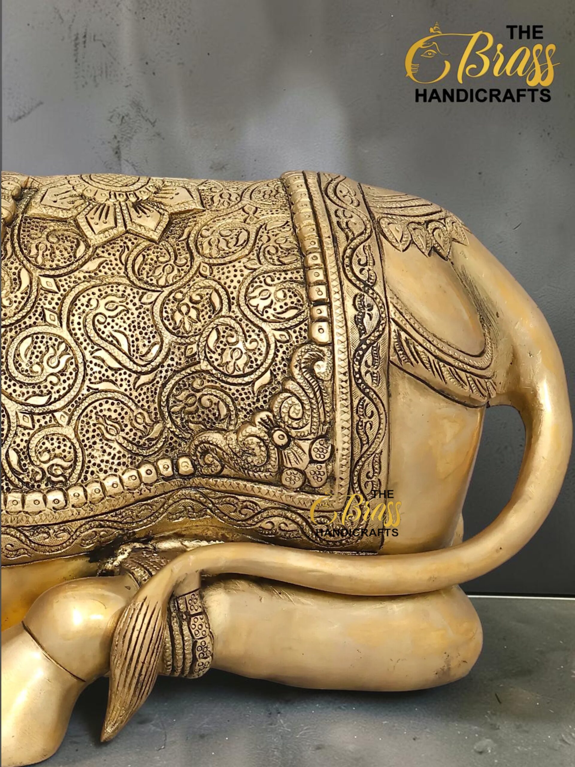 nandi 5 - thebrasshandicrafts.com Gold-toned elephant statue with intricate embossed designs and a patterned saddle, watermark 'The Brass Handicrafts' visible in the corner thebrasshandicrafts.com