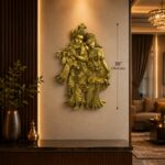 Golden statue of Krishna and Radha in brass, mounted on a warm beige wall beside dark wood panels in a luxe lobby setting.  thebrasshandicrafts.com
