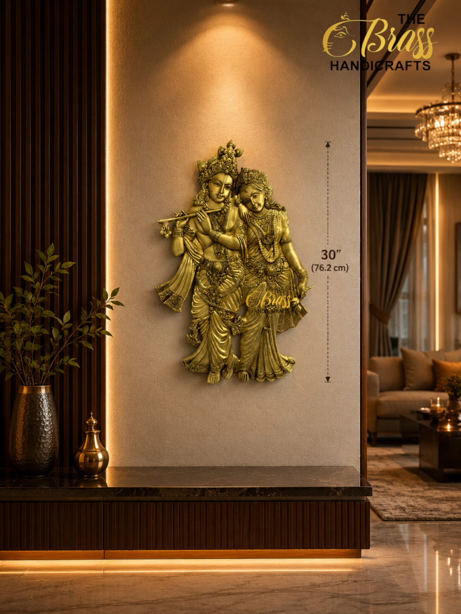 Golden statue of Krishna and Radha in brass, mounted on a warm beige wall beside dark wood panels in a luxe lobby setting.  thebrasshandicrafts.com