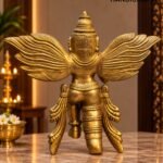 Golden Winged Deity Statue in Warm Altar Light - thebrasshandicrafts.com Golden ceremonial statue with large, detailed wings on a marble surface, softly lit interior in the background. thebrasshandicrafts.com